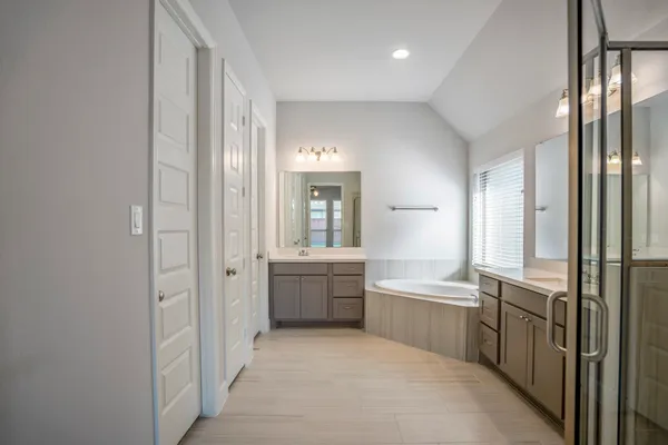 a large en suite bathroom with a tub sink and mirror