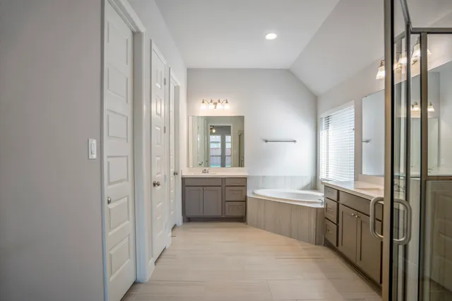 a large en suite bathroom with a tub sink and mirror