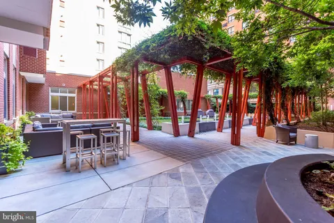 a view of a patio with table and chairs potted plants and large tree