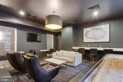 a living room with furniture a lamp and a rug