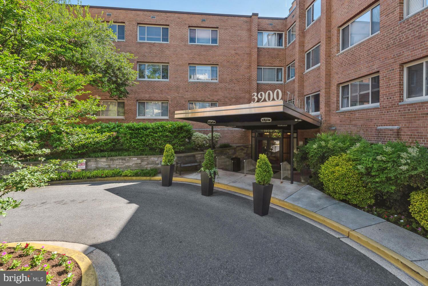 3900 Tunlaw Road Northwest, Unit 406 Washington, DC 20007 - Photo 1 of 23 a view of a brick building with a bench in front of building