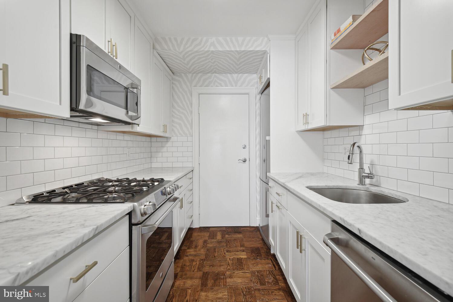 3900 Tunlaw Road Northwest, Unit 406 Washington, DC 20007 - Photo 12 of 23 a kitchen with a sink stove top oven and cabinets
