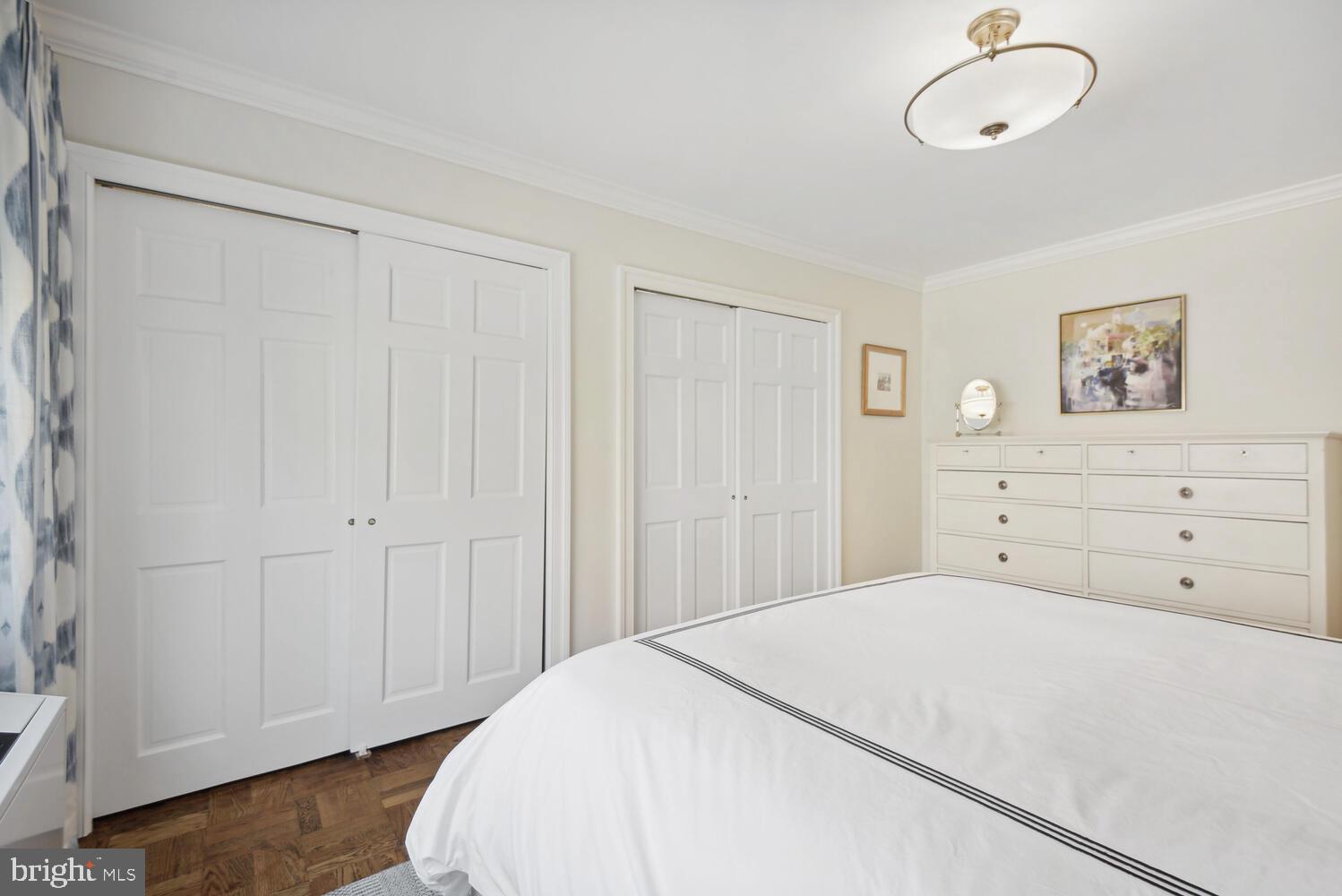 3900 Tunlaw Road Northwest, Unit 406 Washington, DC 20007 - Photo 15 of 23 a spacious bedroom with a bed and a painting on the wall