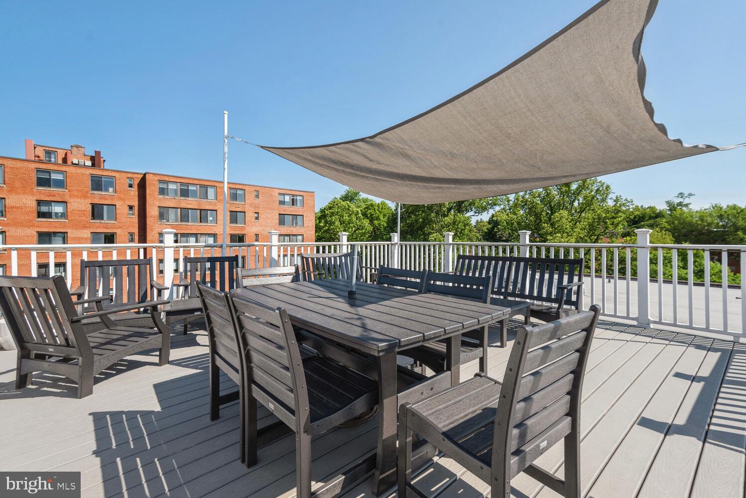 3900 Tunlaw Road Northwest, Unit 406 Washington, DC 20007 - Photo 22 of 23 a patio with wooden floor a yard a barbeque oven and outdoor seating