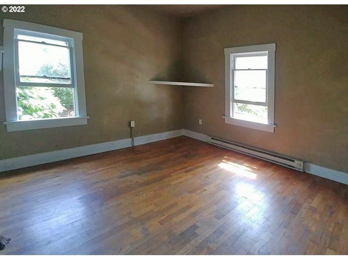 1891 Harris Street Eugene, OR 97403 - Photo 2 of 10 an empty room with wooden floor and windows