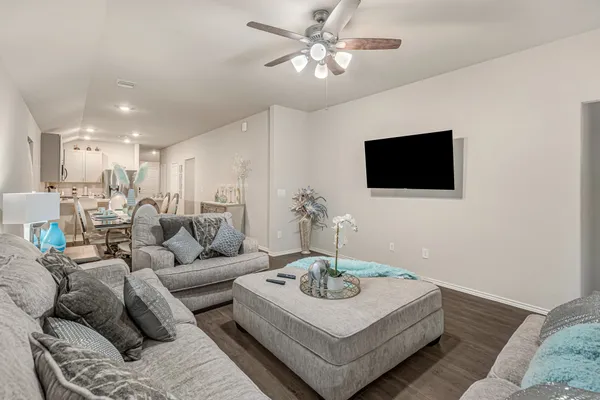 a living room with furniture a flat screen tv and a window