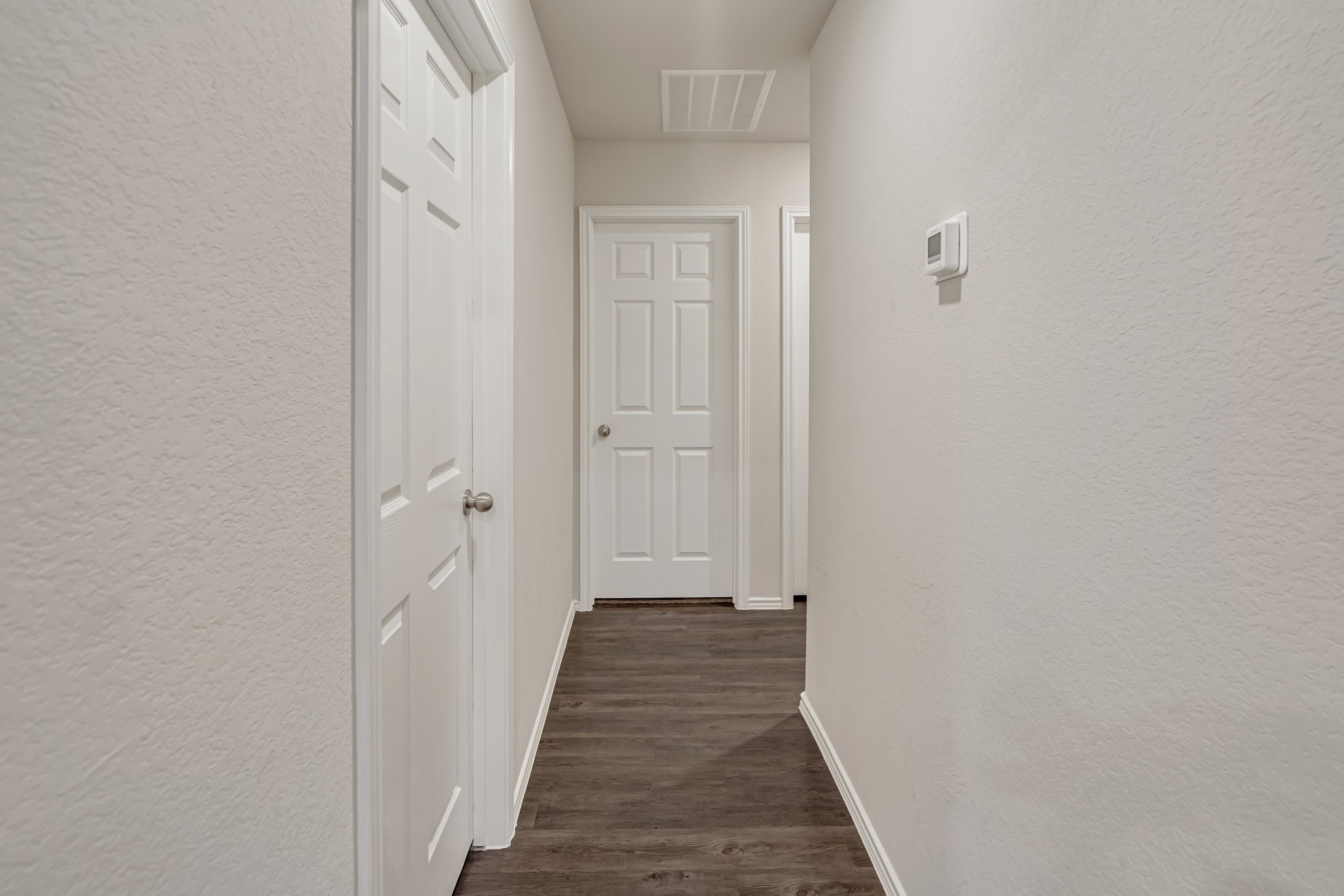 9921 Spring Creek Road Cleveland, TX 77327 - Photo 25 of 30 a view of a hallway with wooden floor and a bathroom