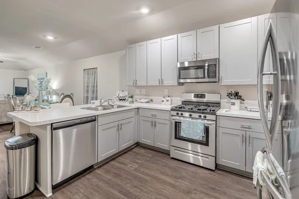 a kitchen with kitchen island granite countertop a sink cabinets and stainless steel appliances