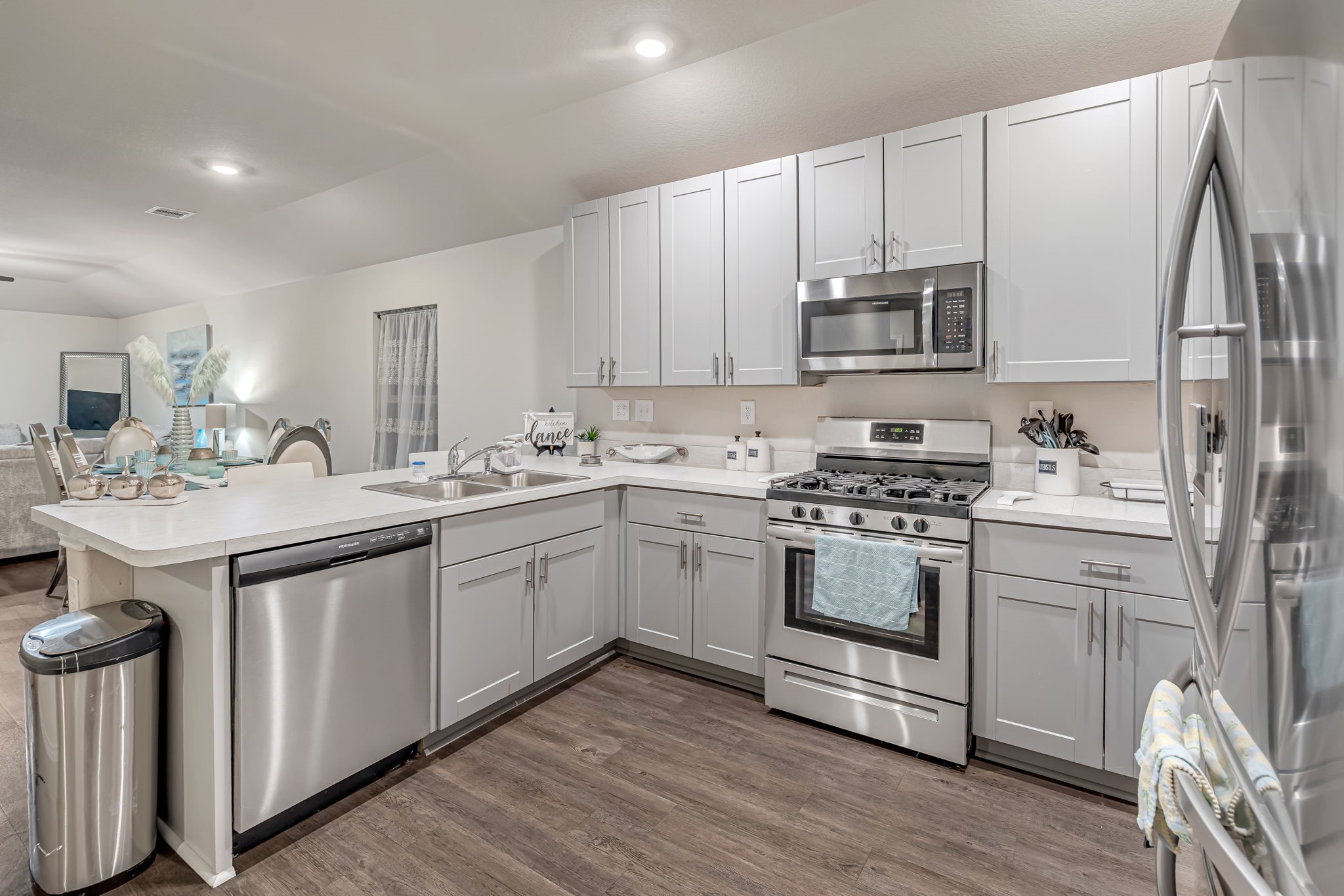 9921 Spring Creek Road Cleveland, TX 77327 - Photo 5 of 30 a kitchen with kitchen island granite countertop a sink cabinets and stainless steel appliances