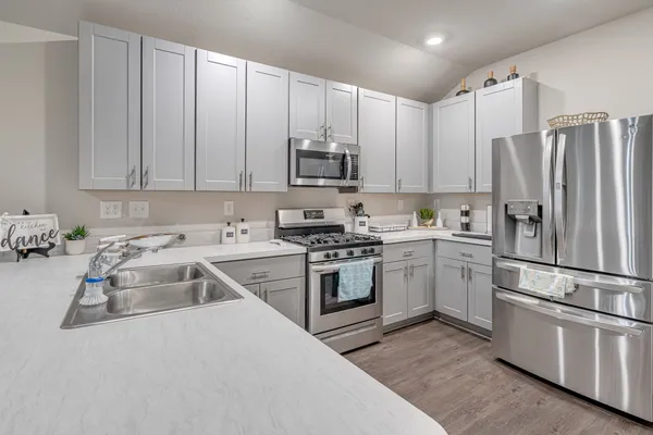 a kitchen with appliances a sink and lots of cabinets