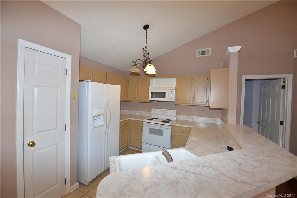 12515 Newstead Road Huntersville, NC 28078 - Photo 8 of 14 a kitchen with kitchen island white cabinets and stainless steel appliances