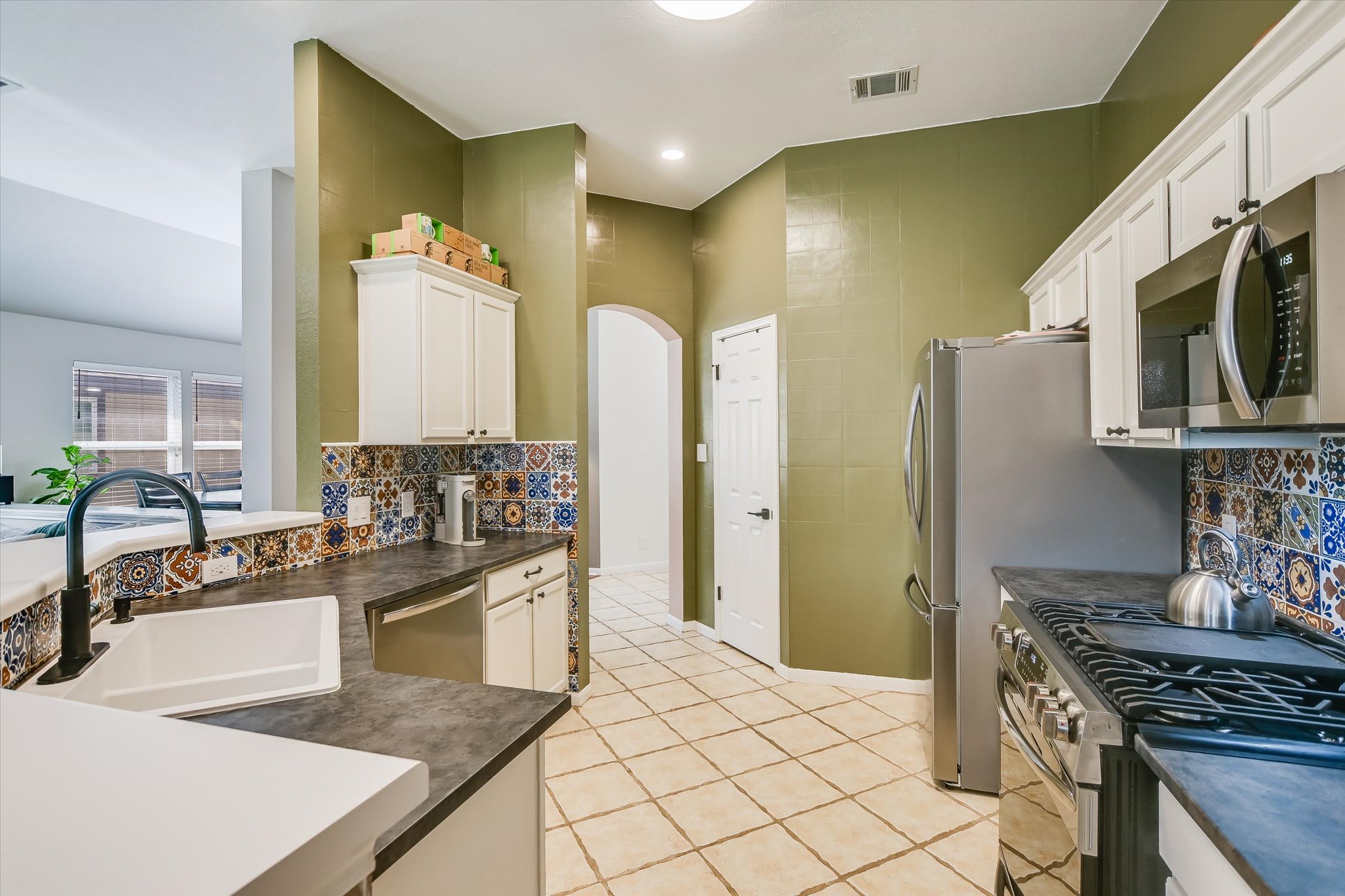 1302 Redbud Lane Leander, TX 78641 - Photo 6 of 28 a kitchen with stainless steel appliances granite countertop a sink stove and refrigerator