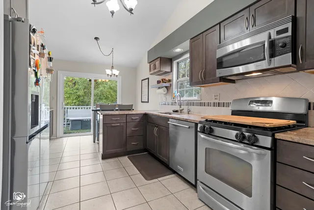 a kitchen with stainless steel appliances granite countertop a stove a sink and a microwave