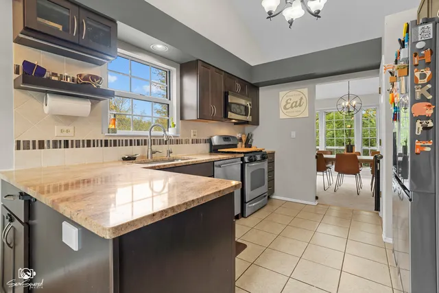 a kitchen with a stove a sink a dining table and chairs