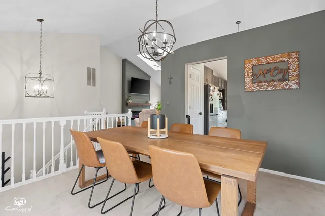 a view of a dining room with furniture a chandelier and wooden floor