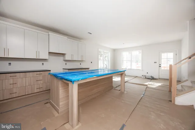 a kitchen that has a lot of cabinets in it and wooden floors