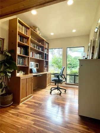 a view of a workspace with furniture and a large window