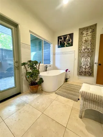 a spacious bathroom with a tub shower and mirror