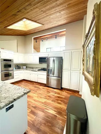 a bathroom with a granite countertop sink toilet and mirror