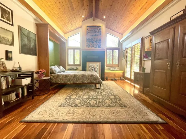 a living room with a couch next to a window with a rug