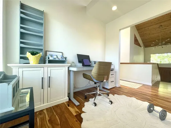 a view of a workspace with furniture and a window