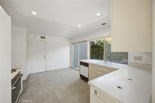 a kitchen with white cabinets and stainless steel appliances