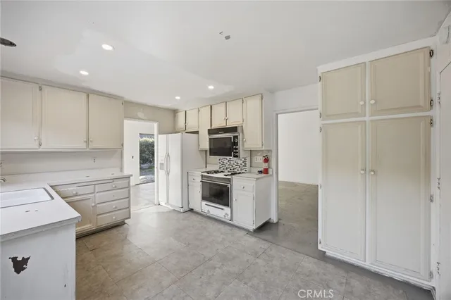 a large white kitchen with a large window