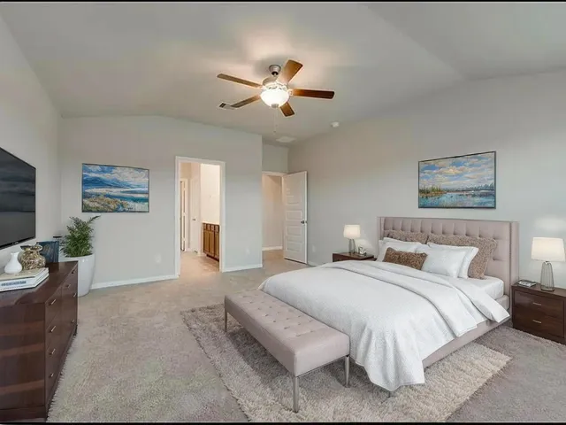 a spacious bedroom with a bed and ceiling fan