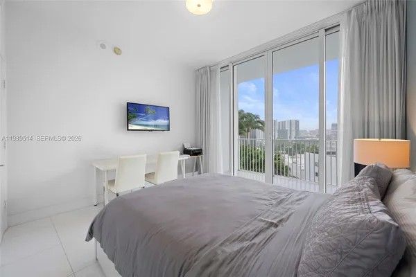 a bedroom with a large bed and a large window