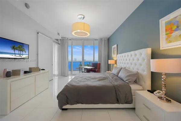 a bedroom with a bed and a lamp on the dresser