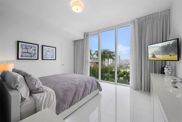 a bedroom with a bed and a flat screen tv