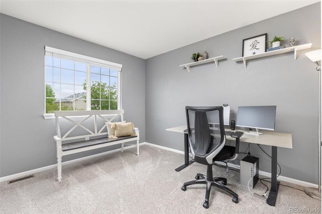 a view of a workspace with furniture and a window