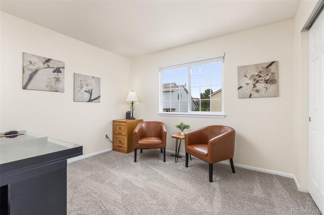 a work room with furniture and paintings on the wall