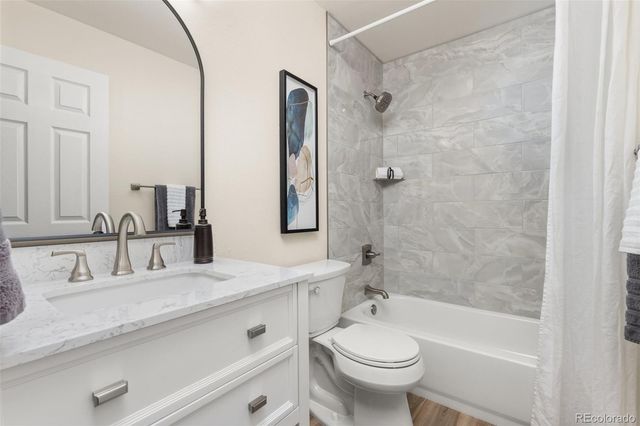 a bathroom with a granite countertop sink a toilet and shower