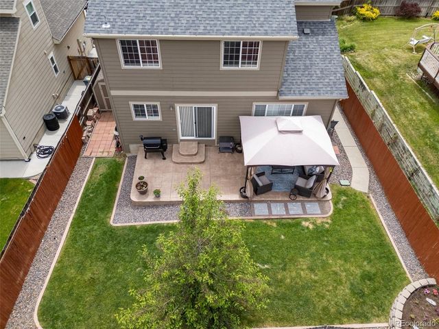 a view of a backyard with table and chairs potted plants