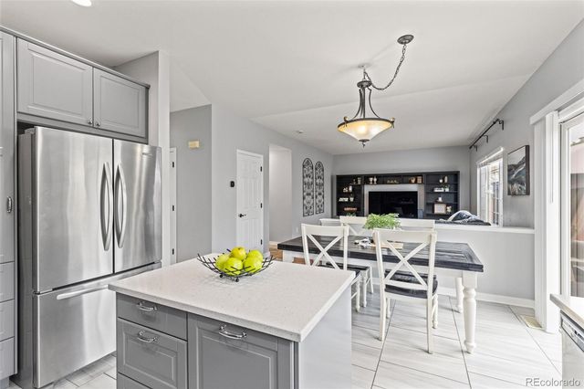 a kitchen with stainless steel appliances a refrigerator a stove a dining table and chairs