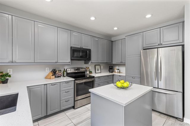 a kitchen with a sink a refrigerator a stove a microwave and cabinets