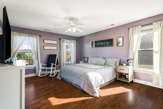 a bedroom with a bed flat screen tv and a window