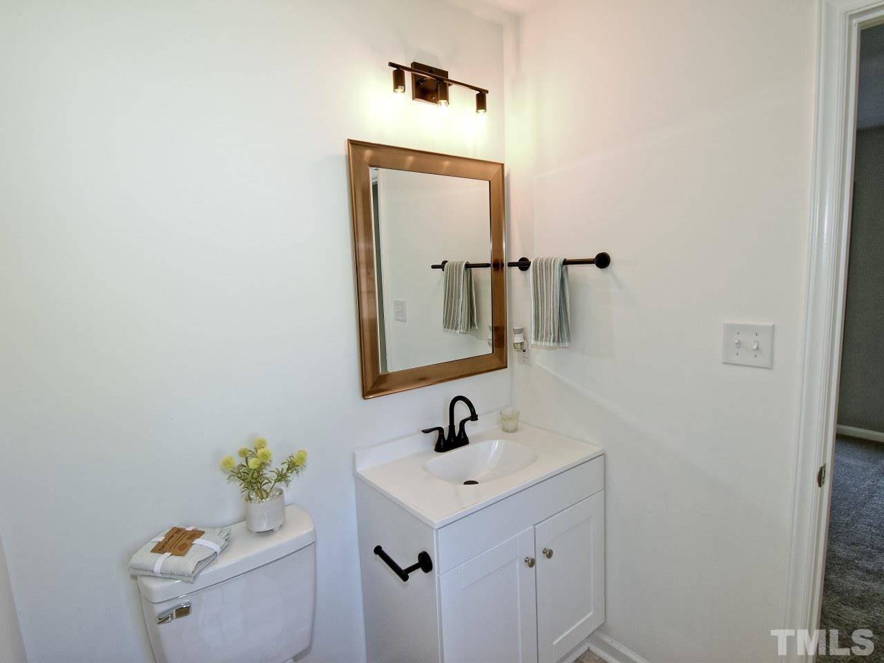 3606 Meriwether Drive Durham, NC 27704 - Photo 16 of 23 a bathroom with a sink a toilet and mirror