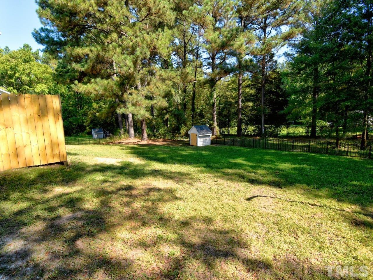 3606 Meriwether Drive Durham, NC 27704 - Photo 21 of 23 a backyard of a house with lots of green space and fountain in front of the house
