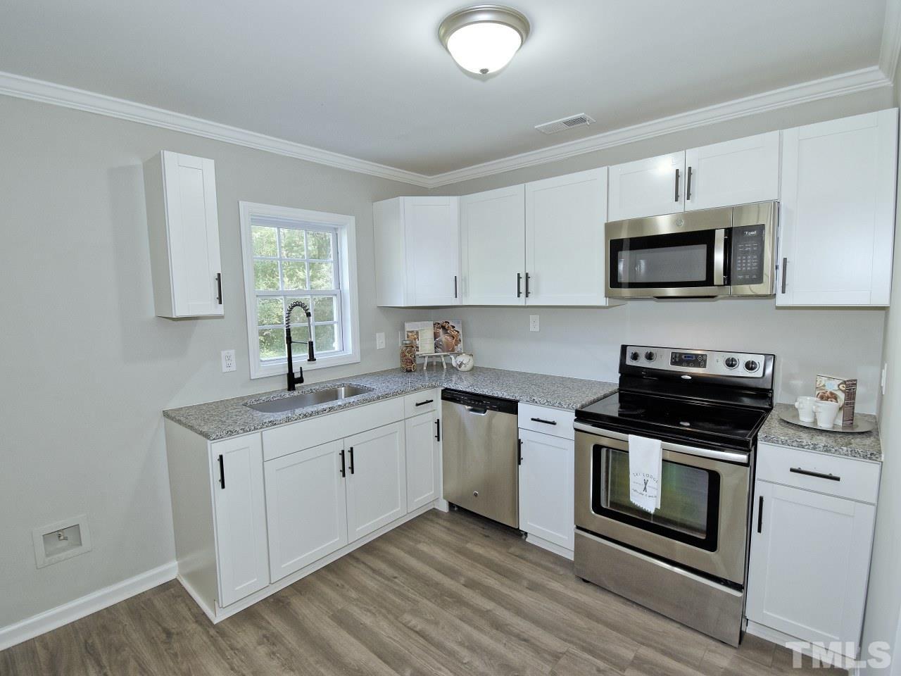3606 Meriwether Drive Durham, NC 27704 - Photo 7 of 23 a kitchen with stainless steel appliances granite countertop a stove a sink and a microwave
