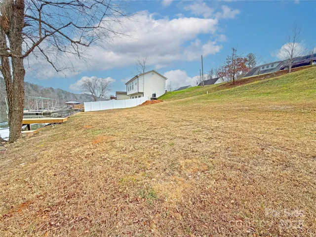 a backyard of a house with lots of green space and lake view