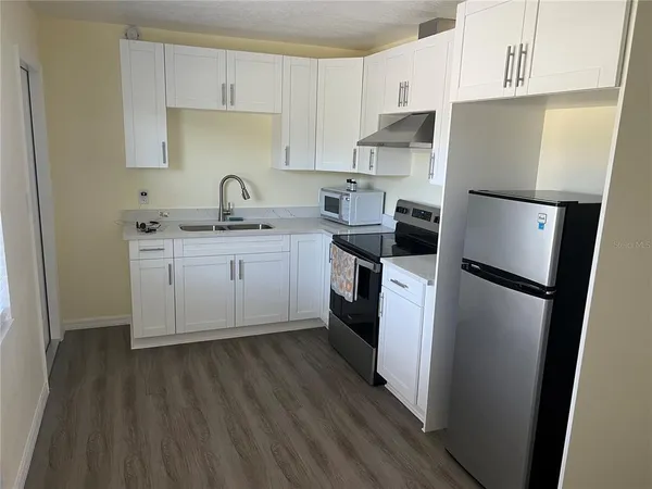 a kitchen with stainless steel appliances granite countertop a stove a refrigerator and a microwave