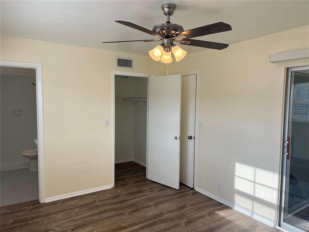 1433 South Belcher Road, Unit B7 Clearwater, FL 33764 - Photo 18 of 25 an empty room with wooden floor chandelier fan and closet