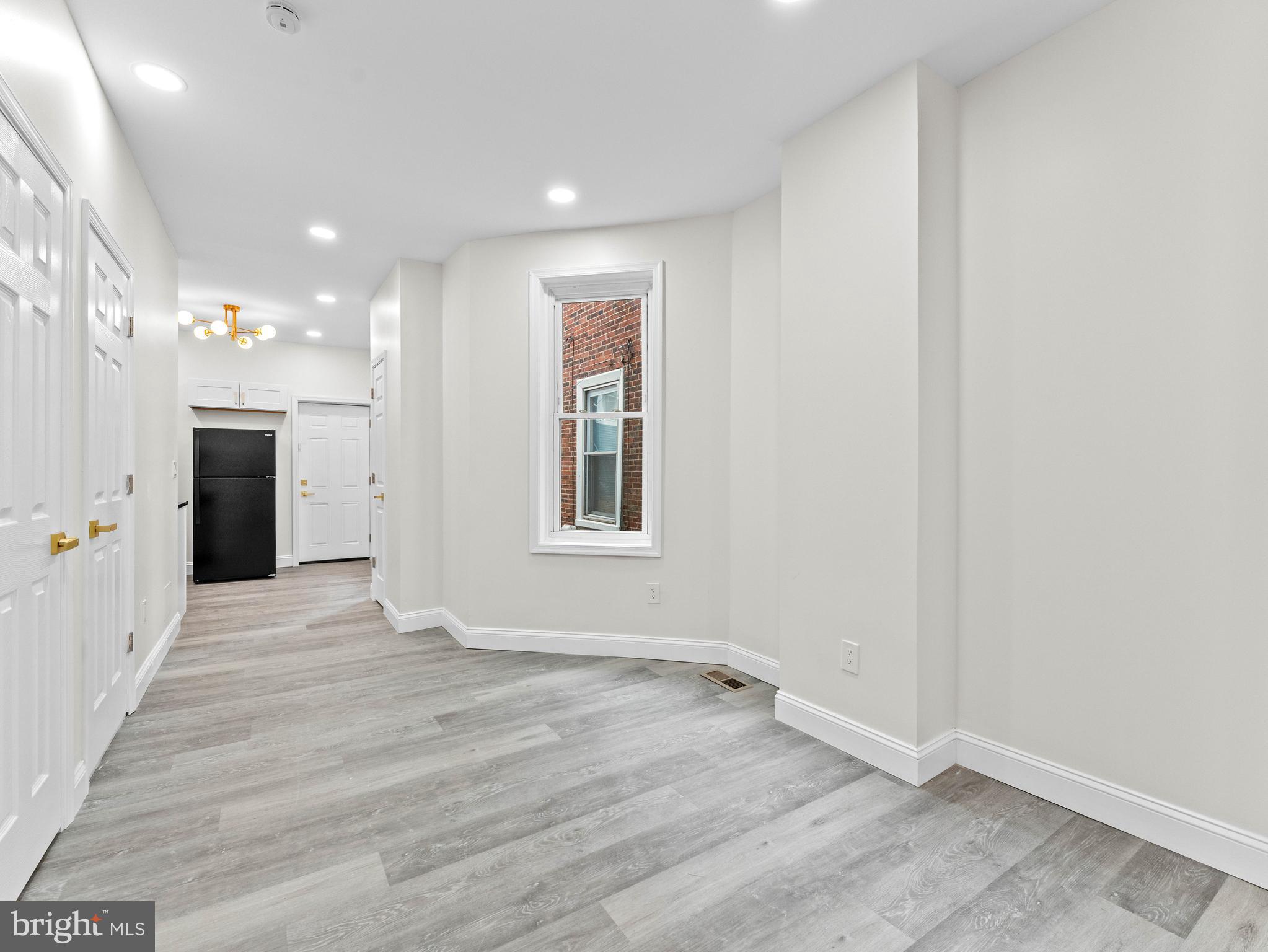 5422 Regent Street Philadelphia, PA 19143 - Photo 11 of 35 an empty room with a kitchen and natural light