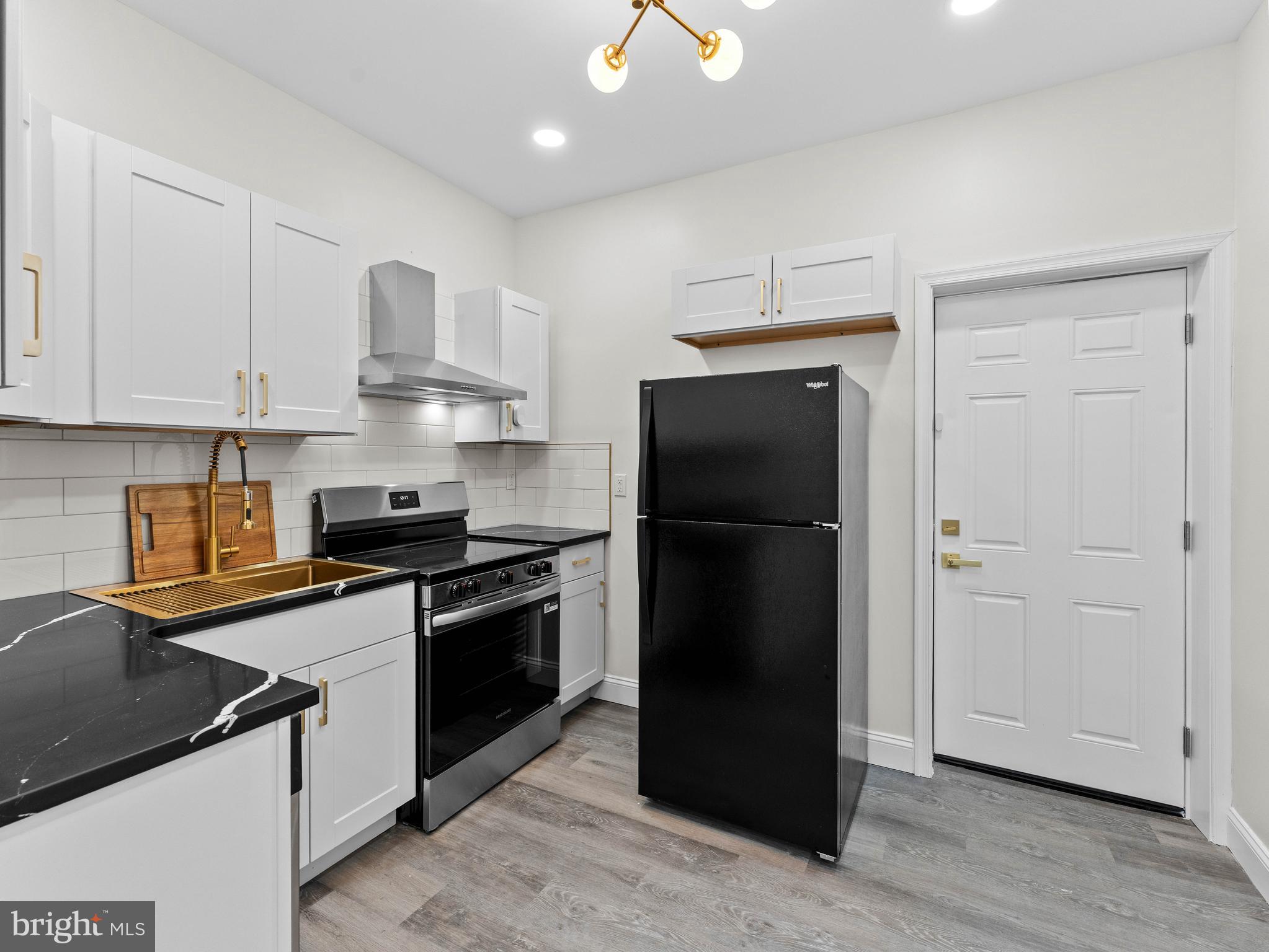 5422 Regent Street Philadelphia, PA 19143 - Photo 12 of 35 a kitchen with stainless steel appliances granite countertop a refrigerator and a stove
