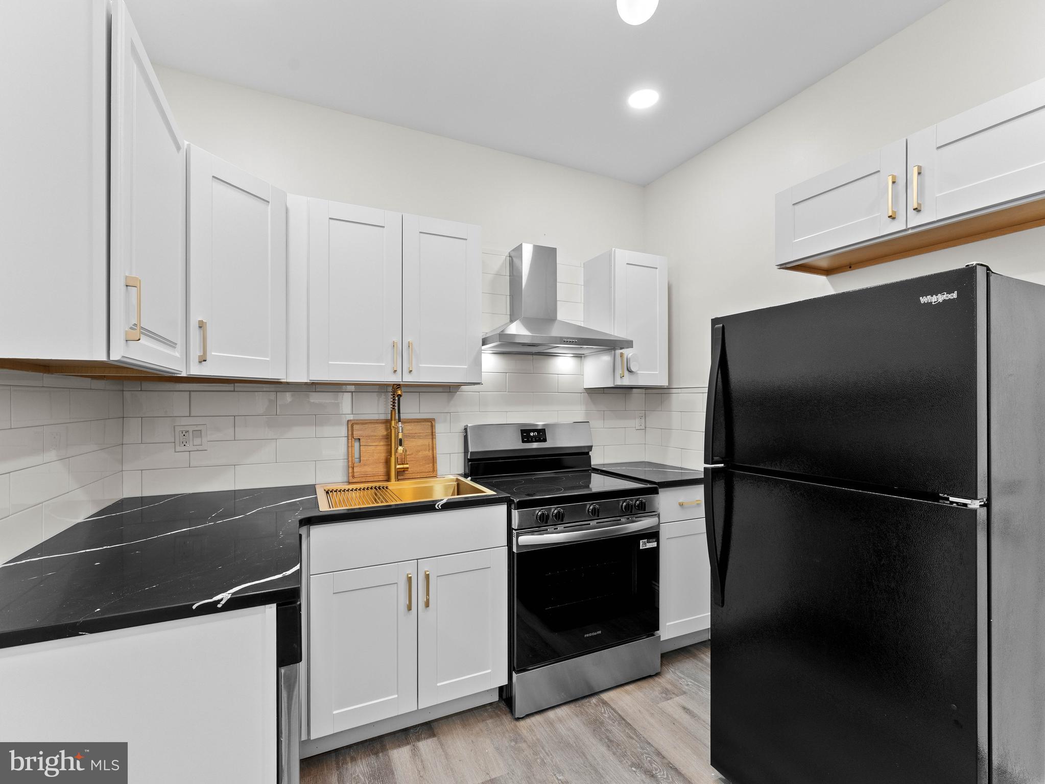 5422 Regent Street Philadelphia, PA 19143 - Photo 13 of 35 a kitchen with a sink stainless steel appliances and cabinets