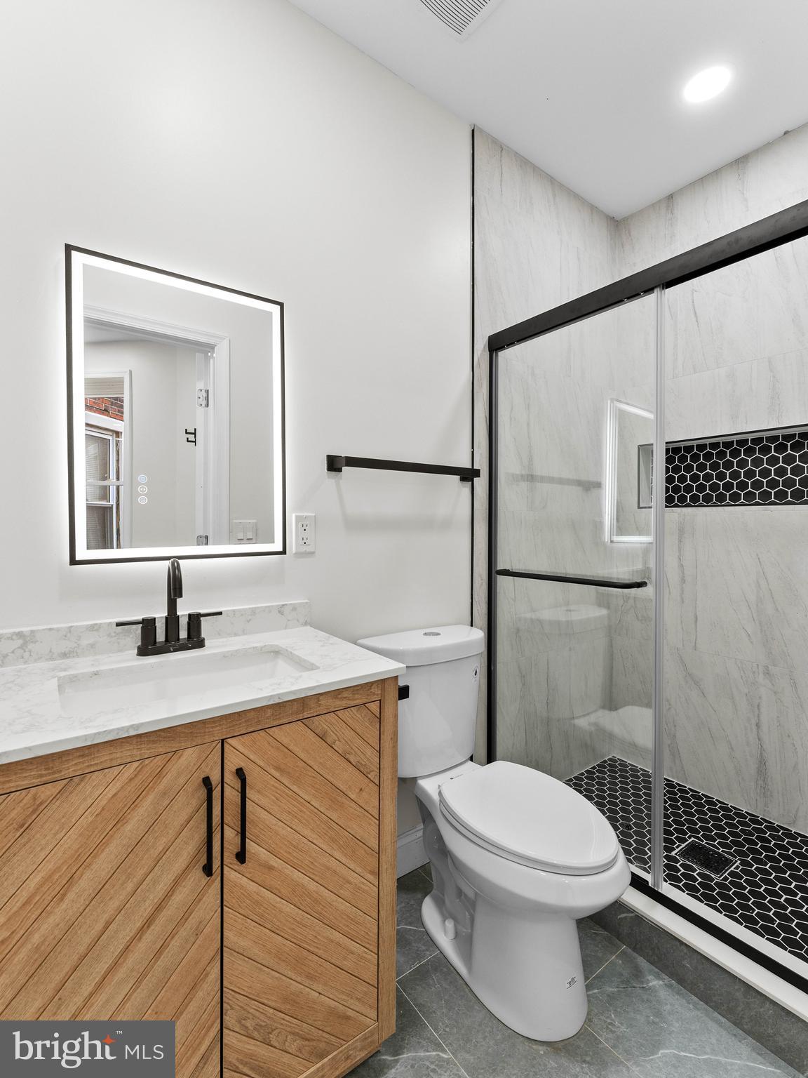 5422 Regent Street Philadelphia, PA 19143 - Photo 15 of 35 a bathroom with a granite countertop sink toilet a mirror and shower