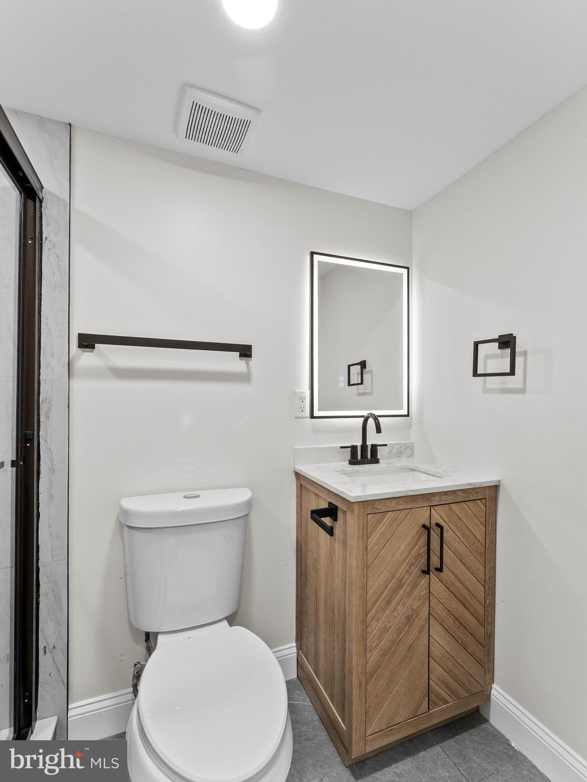 5422 Regent Street Philadelphia, PA 19143 - Photo 32 of 35 a bathroom with a toilet a sink and mirror