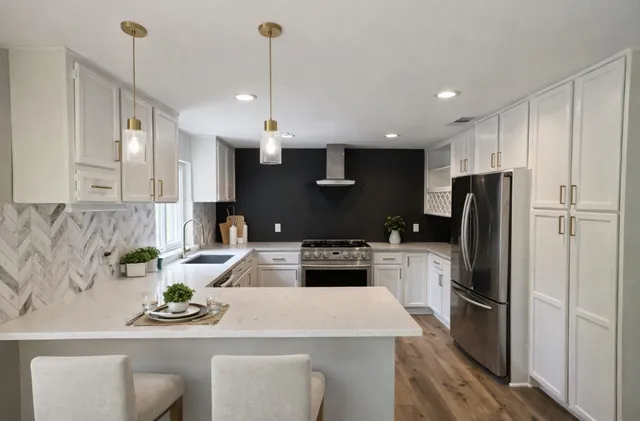 a kitchen with refrigerator a sink and chairs